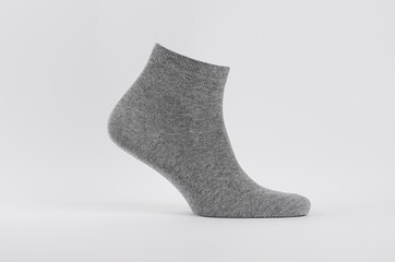 Grey black cotton short sock on invisible foot as mock up for advertising, branding, design. Side view, sportwear template on white background.