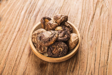 Dried shiitake mushrooms on wooden planks background