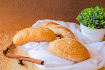 Freshly baked delicious bread on wooden table with white cloth