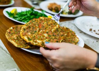 A person serving Turkish pizza