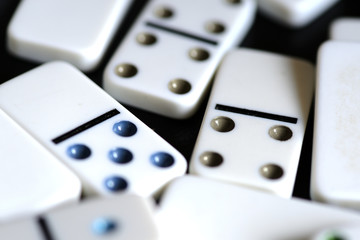 White domino scattered on a black background close-up