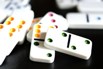 White domino scattered on a black background close-up