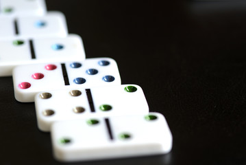 White domino scattered on a black background close-up