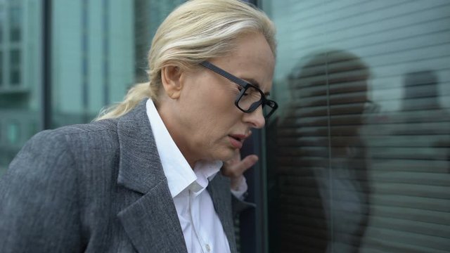 Aged business woman suffering heart attack, taking eyeglasses off, disease