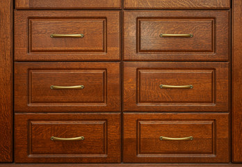Wooden chest of with drawers with metal handles closeup