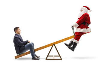 Young man sitting on a seesaw with Santa Claus