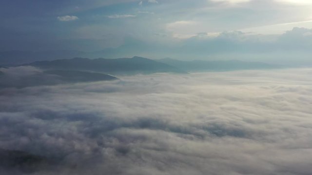 Landscape of Morning Mist with Mountain Layer. Wide shot aerial drone footage. Mountain view morning of Top hill around with the ocean of mist with clouds moving in cloudy sky background. 