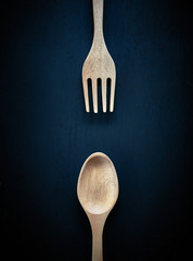 Wooden spoon and fork. On dark  table background