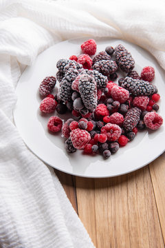Frozen raspberry, blueberry, cranberry on black background. Frozen fruit. Top view, flat lay, close up