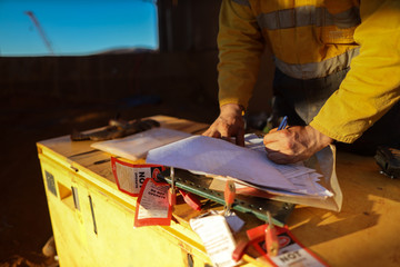 Miner sign of the working at height, confined space permit on isolation safety control lock box...