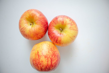 Three fresh apples placed on a white