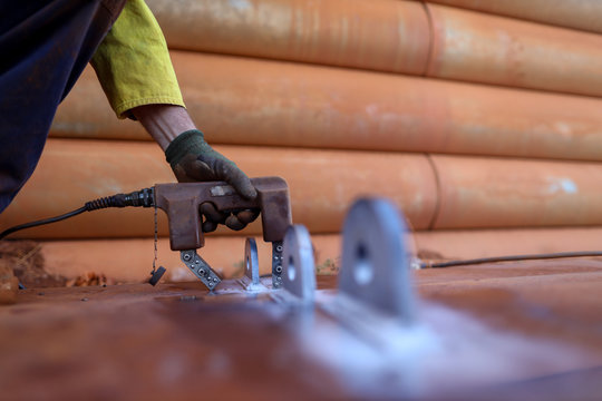NDT technician wearing safety glove spraying black paint while conducting MPI inspection defect crack on welding crane lifting lug prior used mining construction site Perth, Australia   