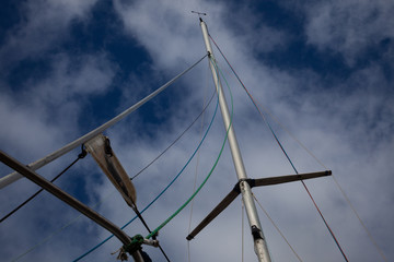 Sailing boat mast against blue cloudy summer sky