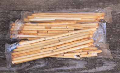 Tasty Italian bread sticks on wooden background