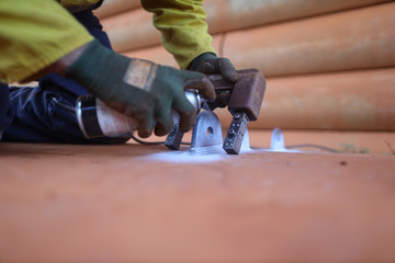 NDT technician wearing safety glove spraying black paint while conducting MPI inspection on crane lifting lug prior used mining construction site Perth, Australia   