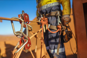 Red pulleys attached on the twins rope access tie line with abseiler ready to work abseiling at the...