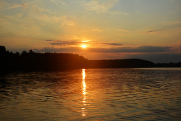 Beautiful Sunset orange lake landscape. The sun's rays are reflected in the water.