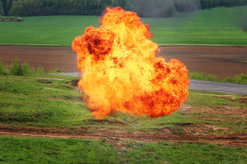 Gas explosion on the outskirts of the forest near the road. A fireball and flames rise into the air.