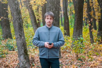 man is talking on the phone in autumn forest