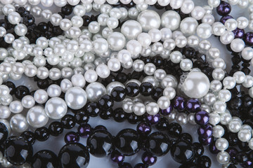Pearl necklace background: white, black and violet beads  