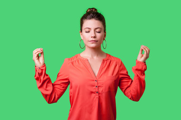 Portrait of peaceful young woman with bun hairstyle, big earrings and in red blouse relaxing and...