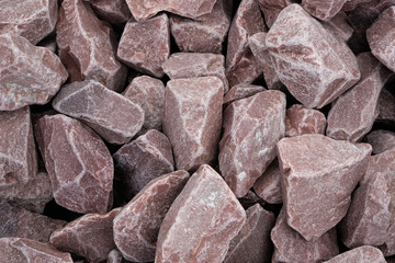 Decorative stone building pebbles close-up macro photo stone designer background. Red Marble crumb. Pebble.