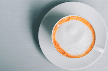 Hot milk tea on white wooden table background. Copy space of food and drink concept.