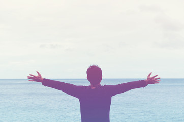 Copy space of man raise hand up on blue sky at beach and island background.