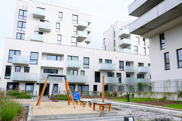 Playground with a hammock and swing in cozy courtyard of modern residential district.