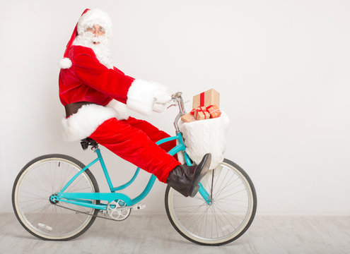 Santa fooling on bike trying to delivering last gifts