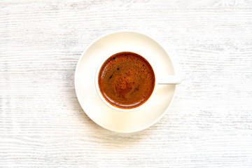 Coffee cup with turkish coffee on white wooden table . Top view    