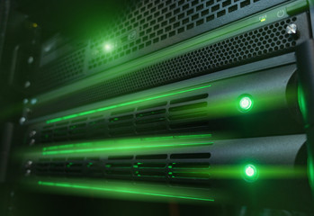 Servers in installed in rack. Green glow light. 