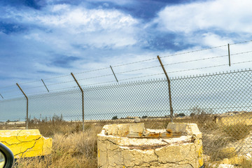 a long and strong fence of border to stop illegal migrants in the middle of desert  