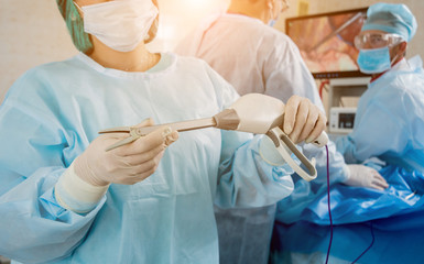 Process of surgery operation using laparoscopic equipment. Group of surgeons in operating room with...