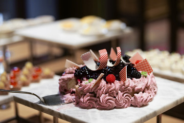 Blueberry cheesecake. Hokkaido blueberry cheesecake with soft focus on the red raspberry along with other sweet dishes at the dessert buffet.