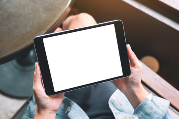 Top view mockup image of a woman holding black tablet with white blank screen