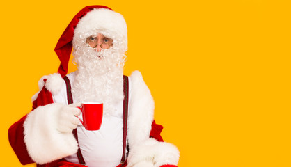 Fototapeta na wymiar Cheerful Santa Claus drinking Christmas cacao from red cup