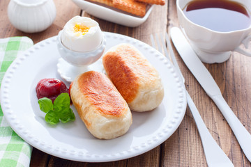 Breakfast with sausages in yeast dough on a wooden table, horizontal