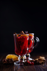 Christmas hot mulled wine in glasses with spices, cranberry and orange slices. Winter warming drink,celebration traditions, home weekend
