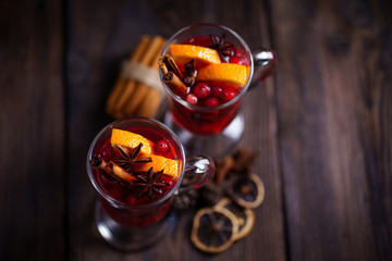 Christmas holidays atmosphere, cold winter day. Warming mood. Mulled wine with cranberry, cinnamon,...