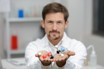 man showing part of molecular model focus on foreground