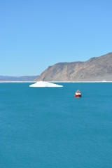 boat in the bay of the Eqip Sermia with icebergs  - melting Eqi Glacier in Greenland Disko Bay,  World of greenland travel - global warming and climate change. Summer, July