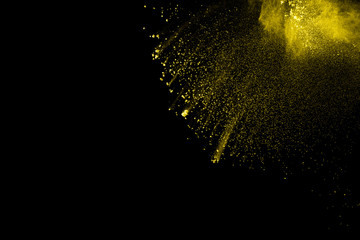 Obraz premium Yellow dust particles explosion on black background.Yellow powder splash.