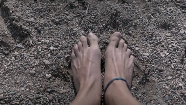 Girl curling her toes in the a sand pebble beach on a late afternoon Summer in Canada 24fps, full HD, 1080p
