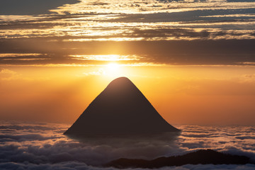 Beautiful sunset and mountain above the clouds in the sky