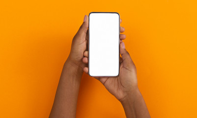 Black hands holding smartphone with blank screen for mockup