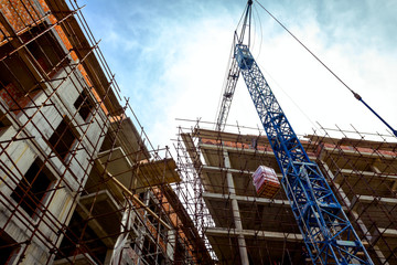 Crane is carry pile red blocks packed in plastic foil