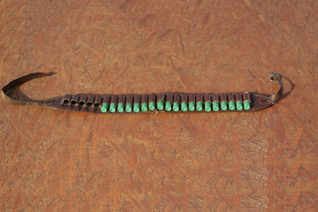 Shotgun cartridges in a bandoleer on a table