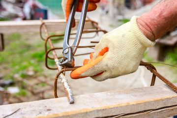 Construction worker binding rebar for reinforce concrete column at the building site.