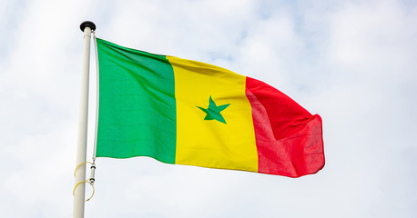 Senegalese flag waving against cloudy sky background
